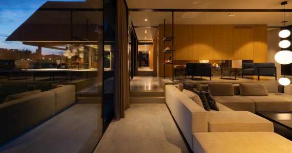 Woning in Maassluis met een gevlinderde betonvloer van Willem Designvloeren gecombineerd met een grijze bank.