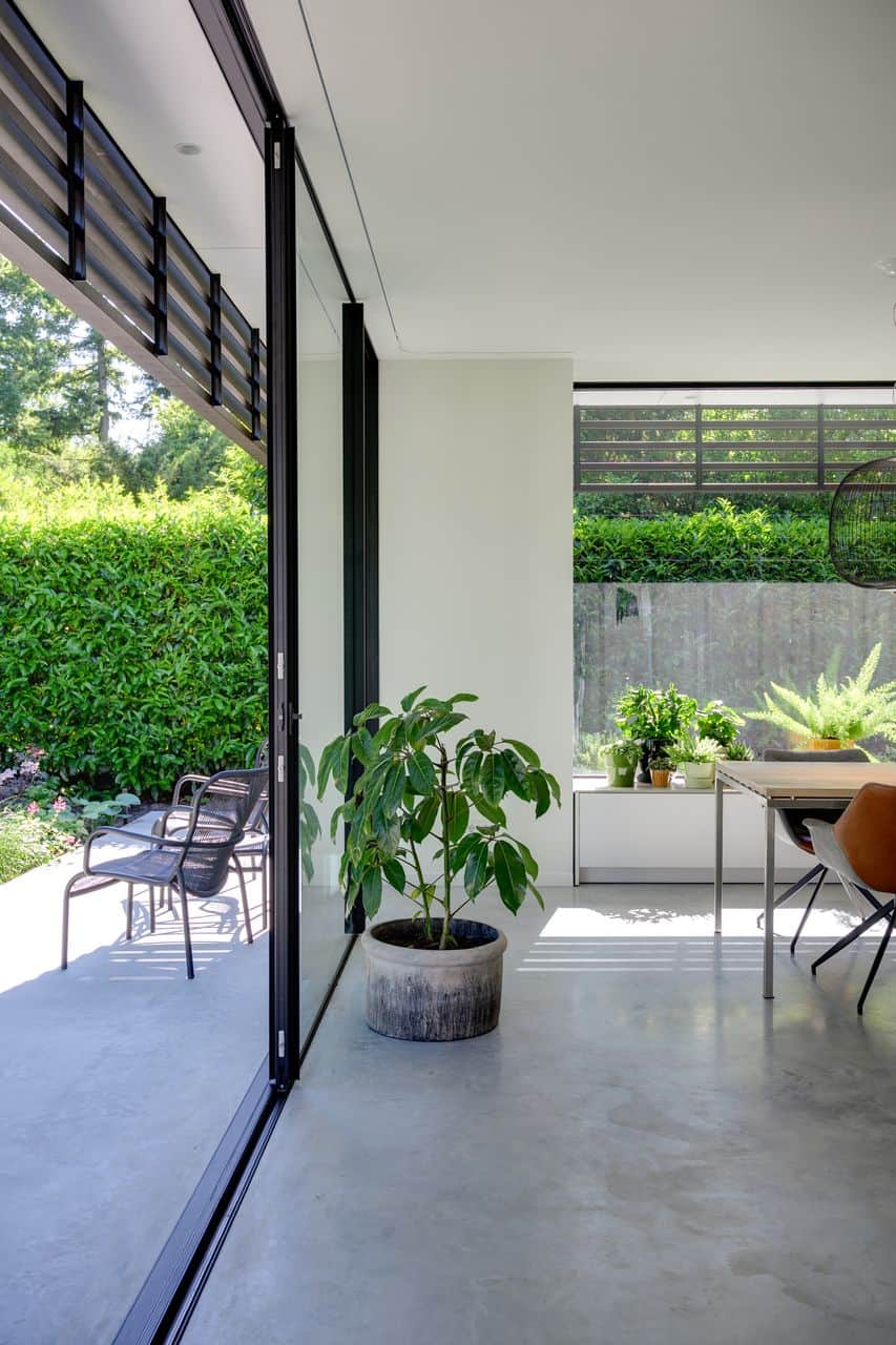 Een foto waar goed te zien is hoe de betonvloer binnen doorloopt naar buiten met enkel een onderbreking van de pui.