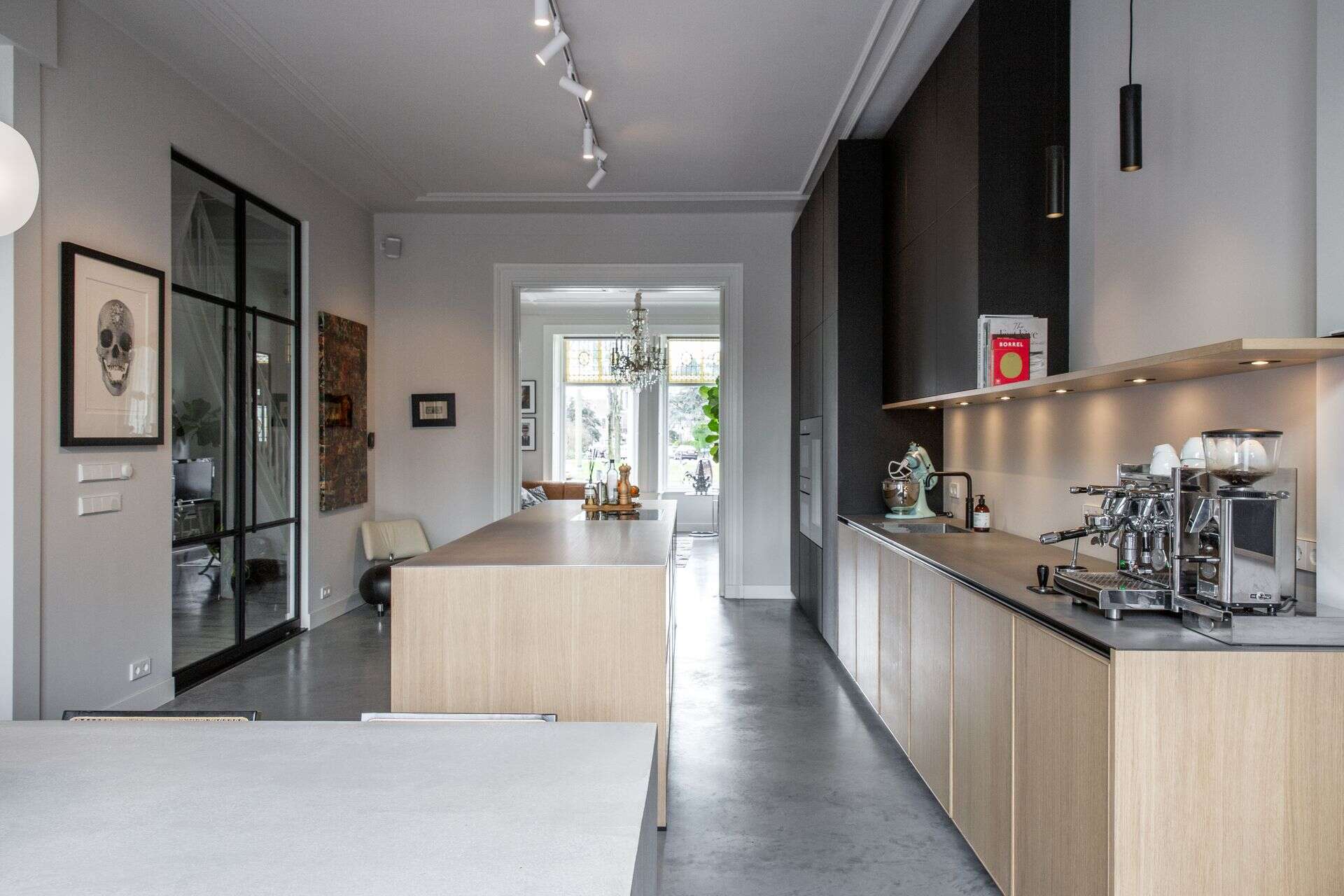 De keuken in dit herenhuis in Den Haag is helemaal verbouwd. Er is gekozen om oude karakteristieke elementen in tact te laten en te combineren met een modere, houten keuken en een grijze gevlinderde woonbetonvloer. 