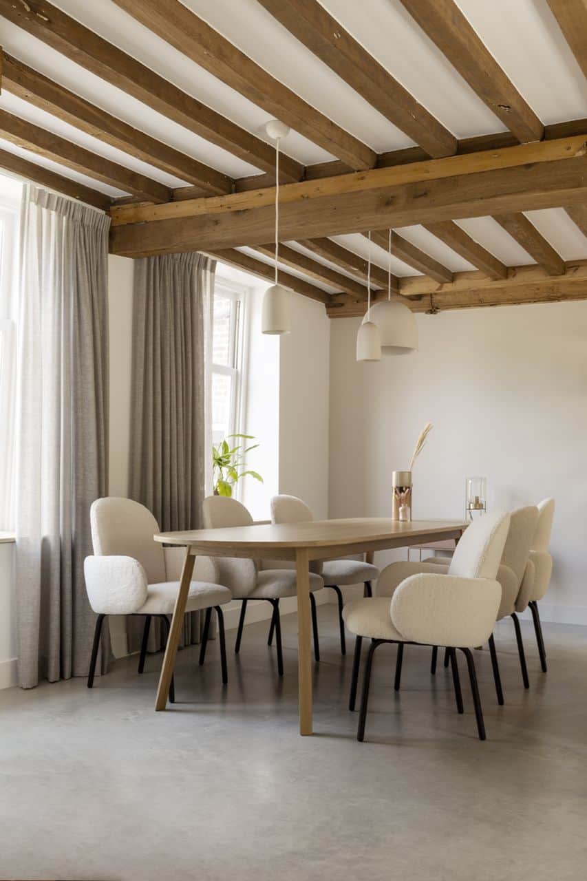 Woning in Kloetinge met een gevlinderde betonvloer van Willem Designvloeren met daarop een houten tafel en teddy stoelen.