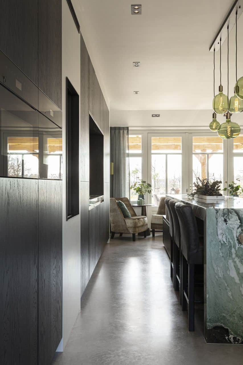 Keuken inspiratie: gevlinderde woonbeton vloer met zwarte eiken keuken en groen marmer werkblad