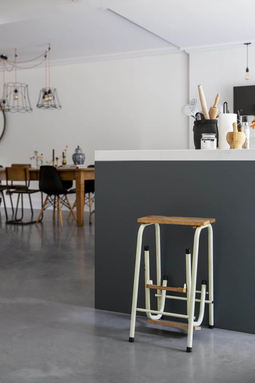 Gevlinderde betonvloer in combinatie met grijsgroene keuken