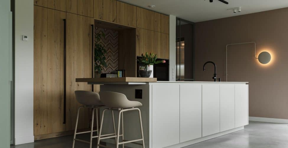 Houten keuken met een wit kookeiland en daaraan beige barkrukken op een gevlinderde betonvloer in Veenendaal.