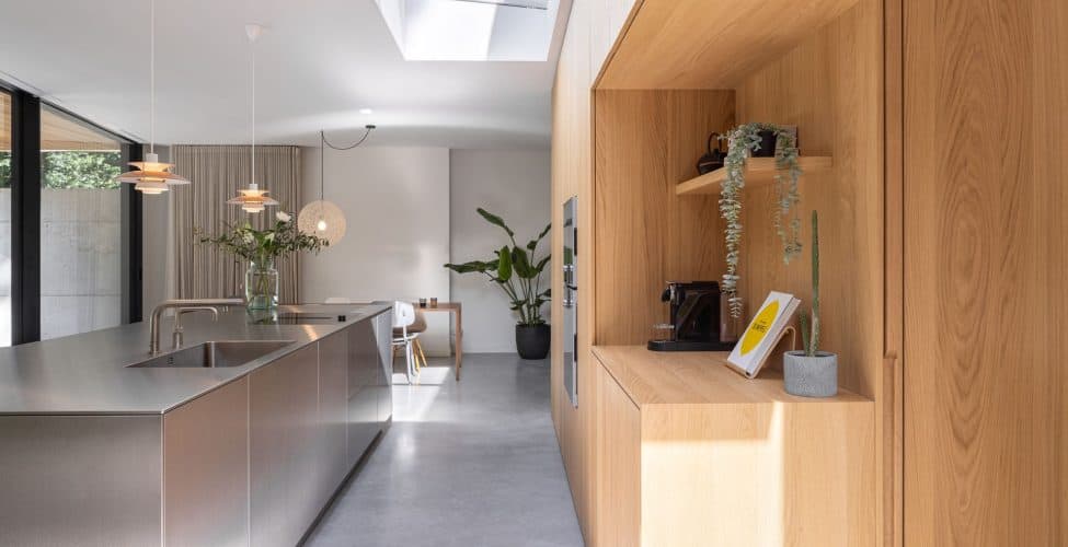 Gevlinderde betonvloer in Zeist met daarop een houten keuken en een RVS kookeiland