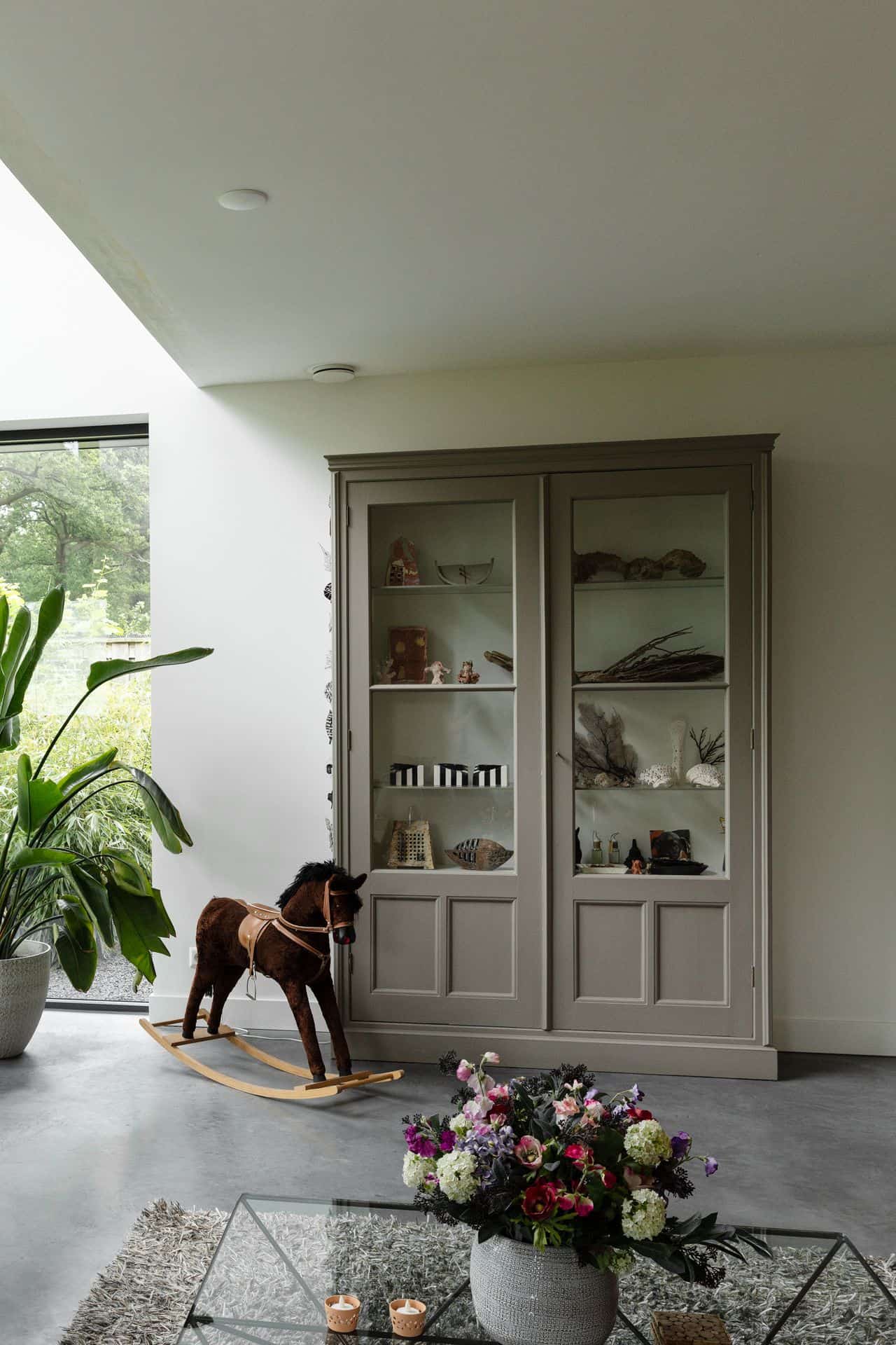 Woning in Woudenberg met een gevlinderde betonvloer. Hierop staat een grijze kast en een hobbelpaardje.