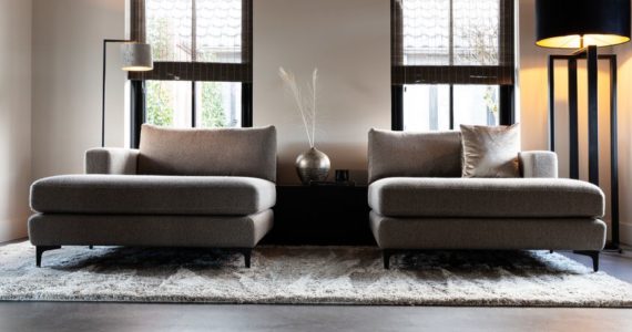 Italiaanse betonlook vloer van Willem Designvloeren in een landelijke woning in Opheusden met daarop twee loveseats.