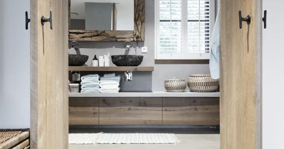 Badkamer met een gevlinderde betonvloer van Willem Designvloeren gecombineerd met veel houten details.