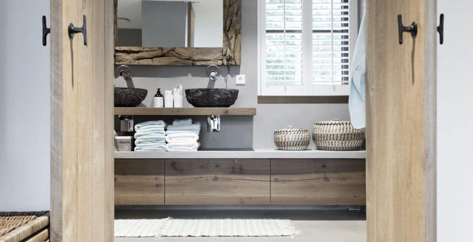 Badkamer met een gevlinderde betonvloer van Willem Designvloeren gecombineerd met veel houten details.