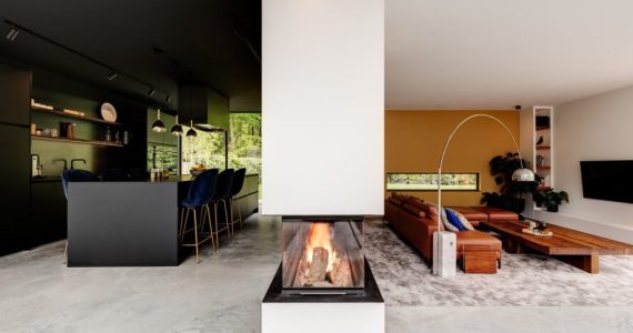 Gevlinderde betonvloer van Willem Designvloeren in de keuken en de woonkamer. Dit is gescheiden door een haard. De keuken is zwart, net als het kookeiland. Aan het kookeiland staat blauwe barkrukken. In de woonkamer ligt een groot vloerkleed met daarop een bruine bank.