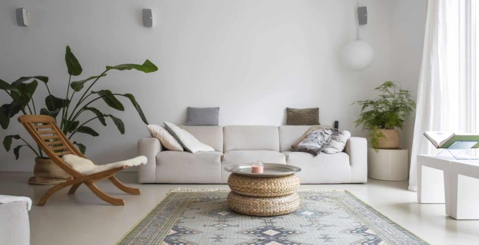 PU gietvloer van Willem Designvloeren in de woonkamer in Zeist. Hierop licht een licht gekleurd vloerkleed, staat een houten stoel en een beige bank. Ook staat er nog een grote plant op de PU gietvloer.