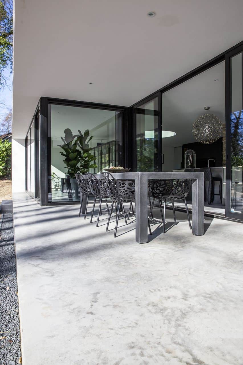 Gevlinderd betonnen terras in Nijmegen met daarop een zwarte tafel en zwarte stoelen.