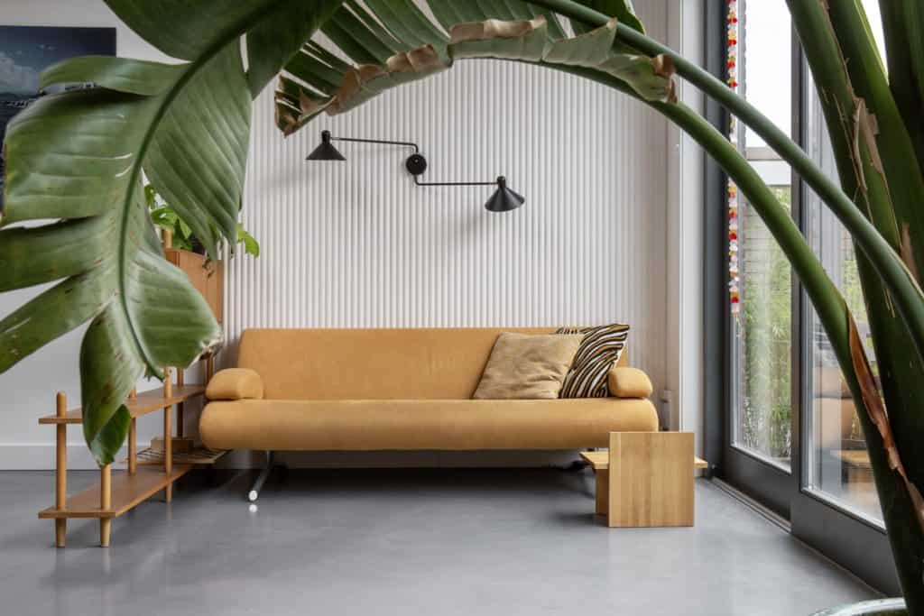 Zithoekje met een gele bank in Haarlem op een gevlinderde betonvloer