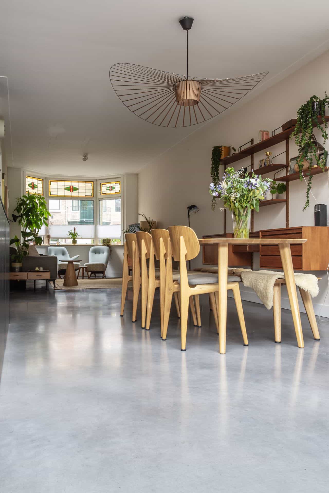 Houten eettafel met houten stoelen op een gevlinderde betonvloer in Haarlem
