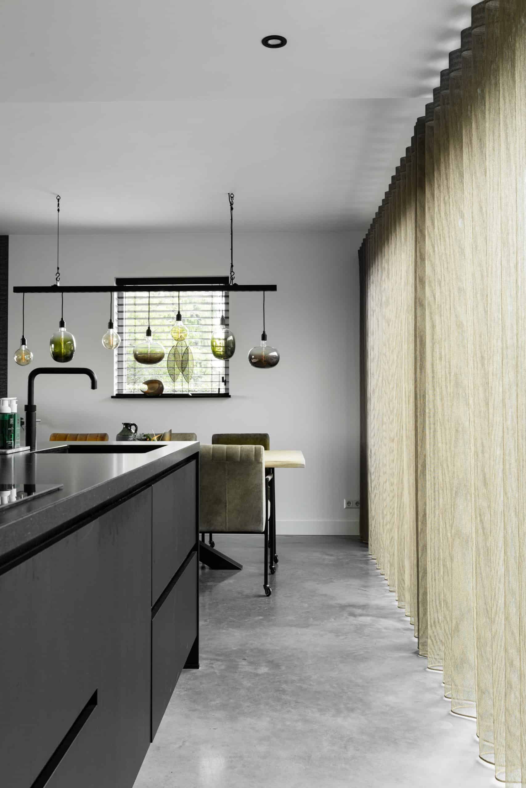 Gevlinderde betonvloer in de keuken van een woning in Hoogblokland. Zwarte keuken