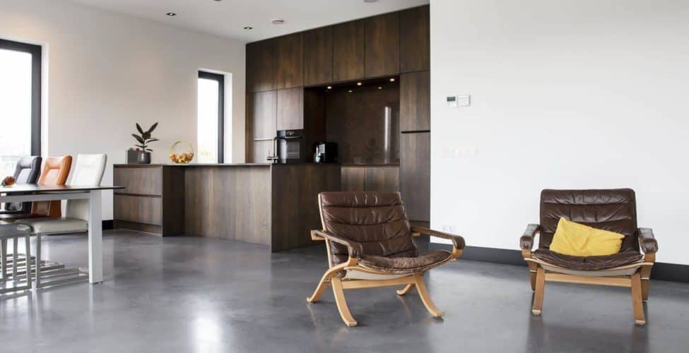 Betonnen vloer in combinatie met een donkere houten keuken