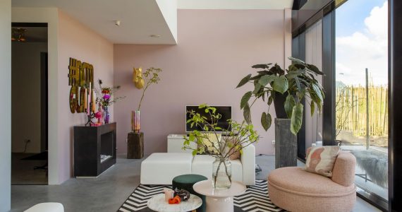 Eclectische woonkamer in Schoonhoven met een gevlinderde betonvloer van Willem Designvloeren gecombineerd met veel kleur en prints.