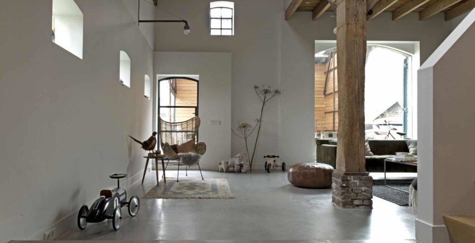 Gevlinderde betonvloer in een boerderij in Driebergen. De vloer is gecombineerd met houten balken en accessoires op de vloer.