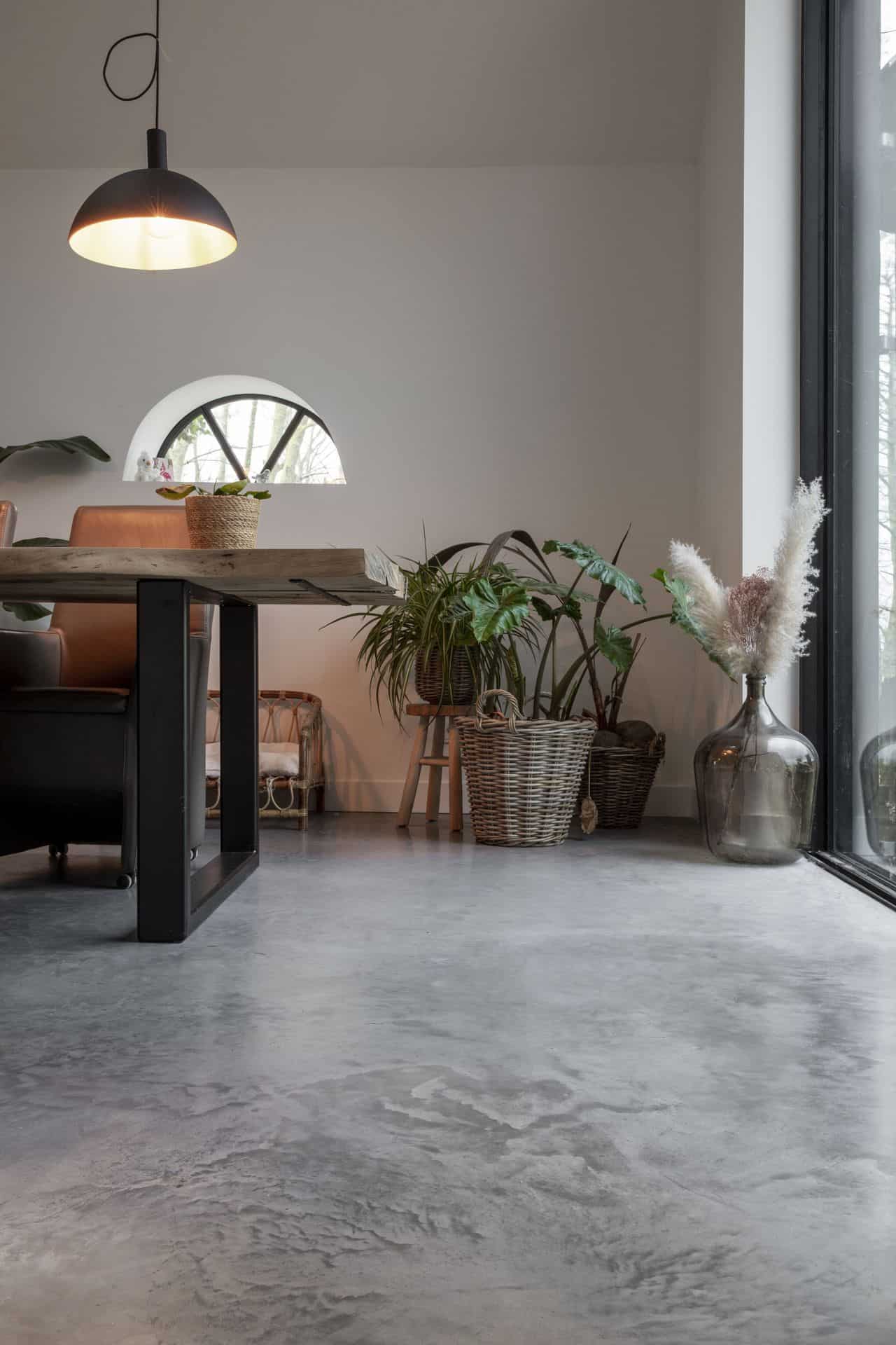 Eetkamer in Schagen met een gevlinderde betonvloer gecombineerd met planten op de grond