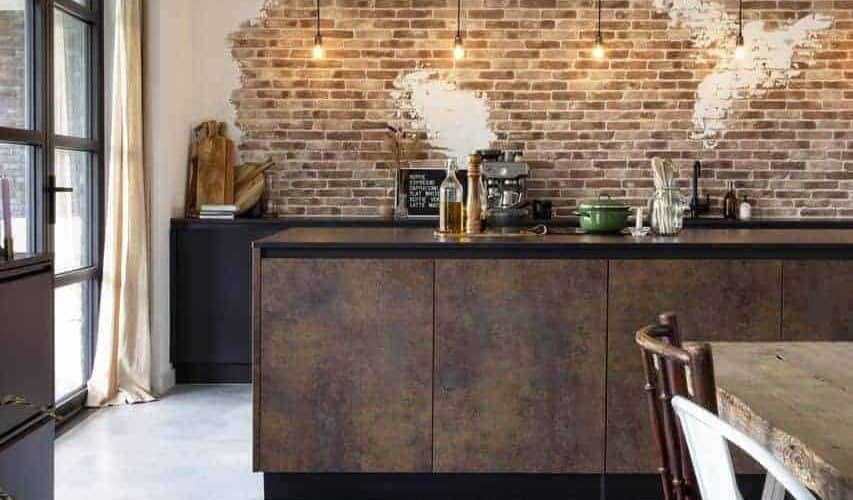 Steensmuur gecombineerd met een industriële keuken op een gevlinderde betonvloer van Willem Designvloeren