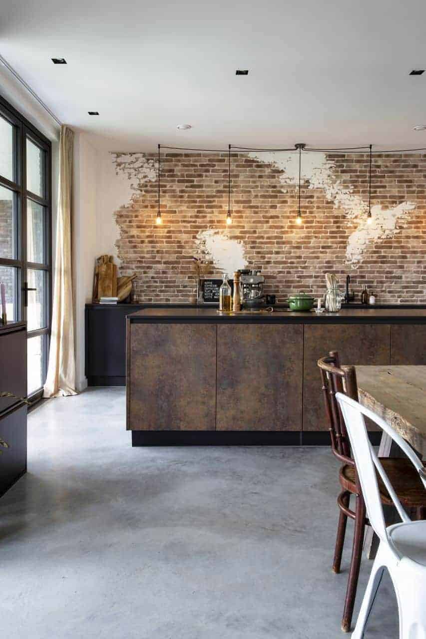 Steensmuur gecombineerd met een industriële keuken op een gevlinderde betonvloer van Willem Designvloeren
